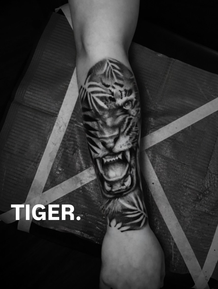 Black-and-grey tiger lower-leg tattoo by Lucas Macauley